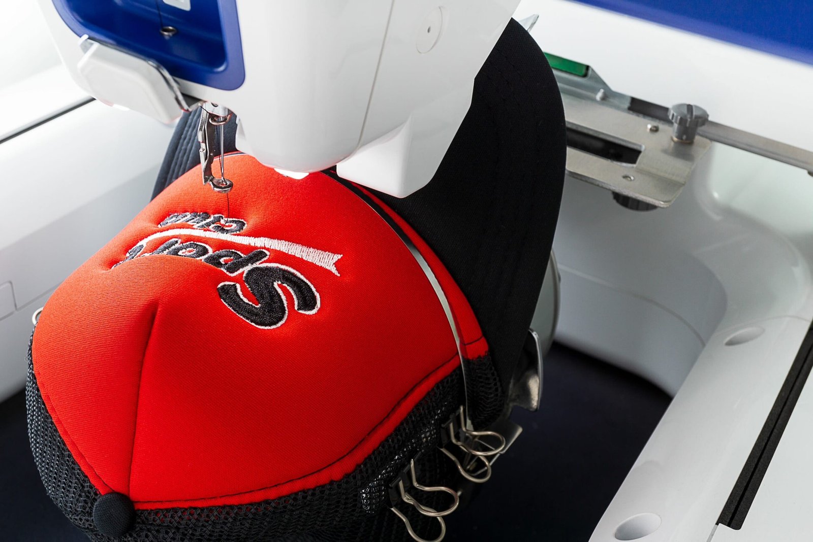 Embroidery machine stitching a red cap